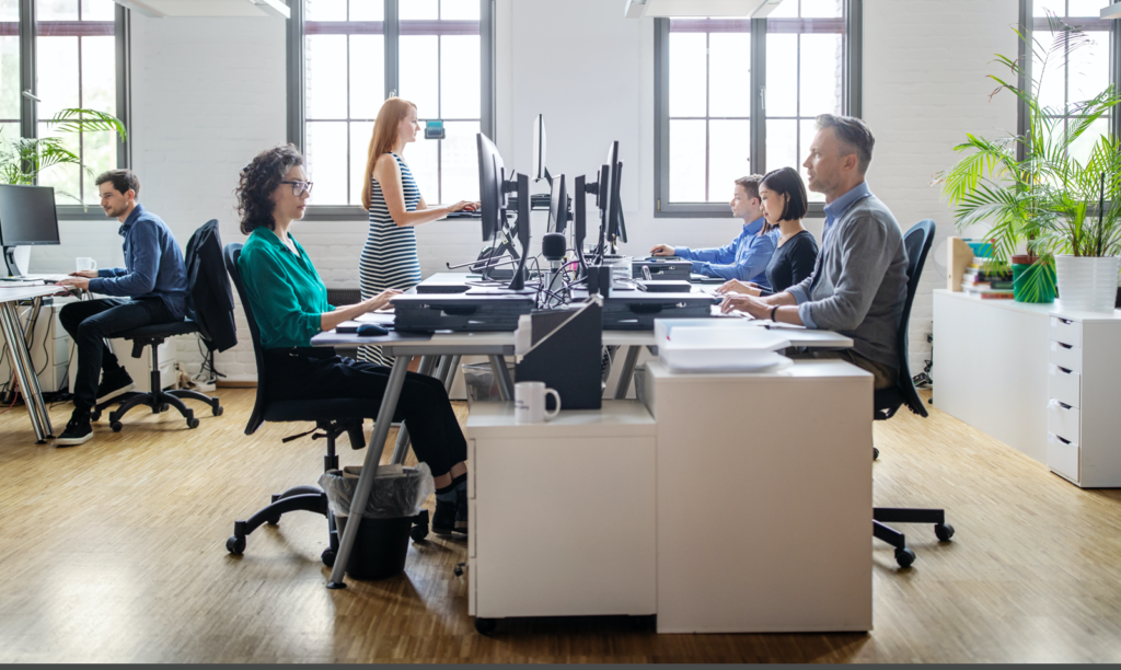 Business people at their desks in a busy, open plan office. Startup business people working at a modern office.